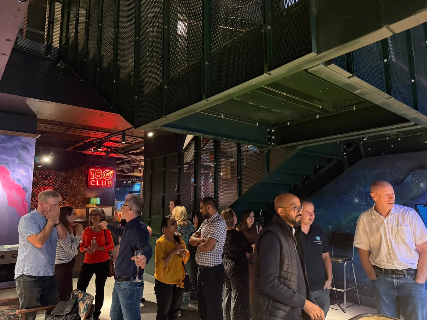 Redhill Business Guild members standing and talking in a dimly lit venue with shuffleboard tables